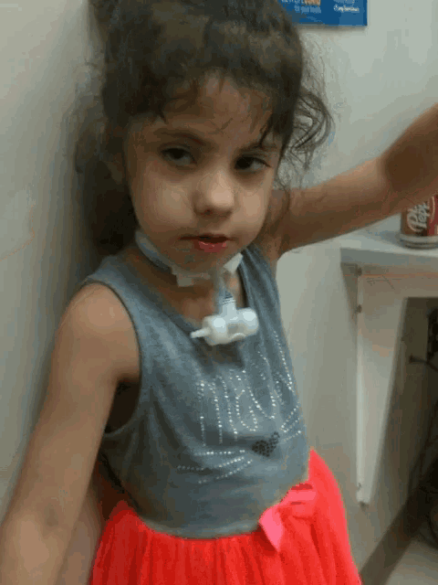 a little girl wearing a gray tank top that says ' mira '