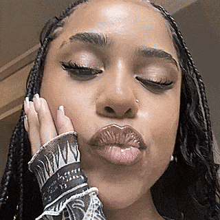 a close up of a woman 's face with her hand on her face .