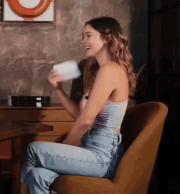 a woman sitting in a chair holding a white object