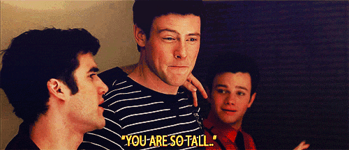 a man in a striped shirt says " you are so tall " to another man