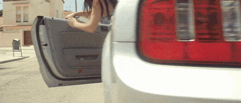 a woman getting out of a car with her door open