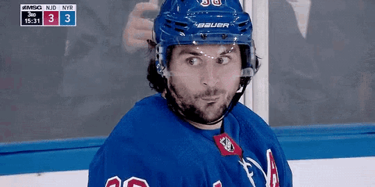 a hockey player wearing a bauer helmet is looking at the camera