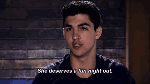 a young man says she deserves a fun night out in front of a brick wall