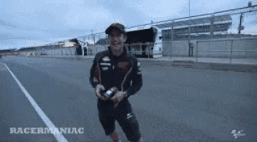 a man is standing on a track holding a remote control .