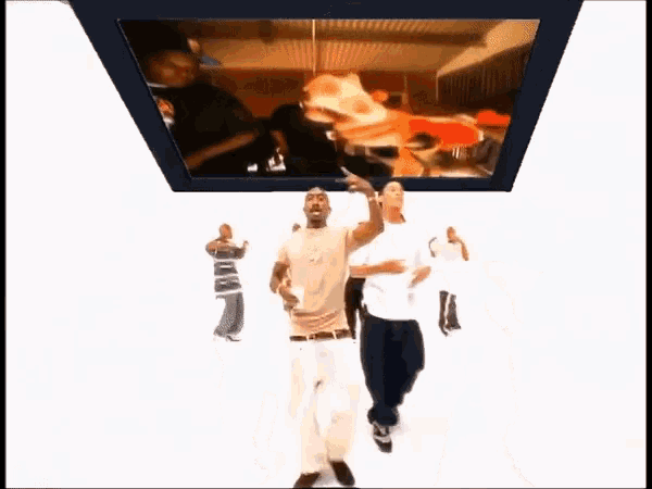 a group of men are dancing in front of a tv screen that says ' nba '