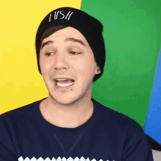 a young man wearing a black beanie with the word lush on it .