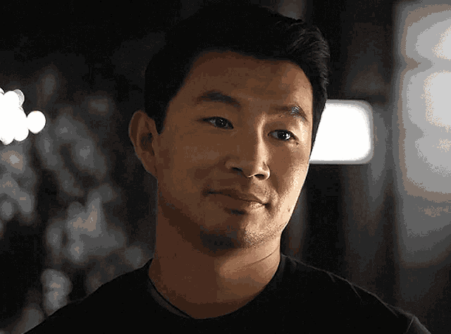 a man in a black shirt looks at the camera