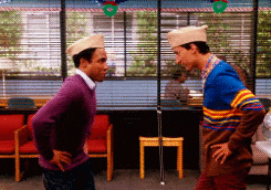 two men are standing next to each other in a room