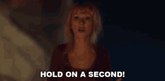 a woman is saying hold on a second in a dark room