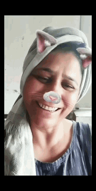 a woman with a towel wrapped around her head and cat ears on her face .