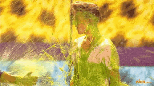 a person is covered in green slime with a nickelodeon logo in the corner .