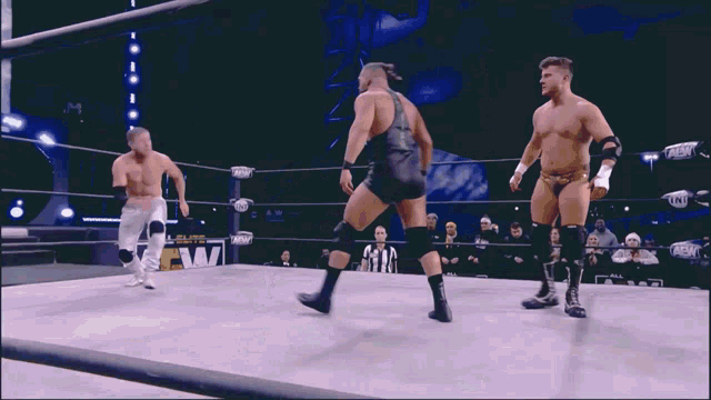 wrestlers in a ring with one wearing a shirt that says ' aew ' on it