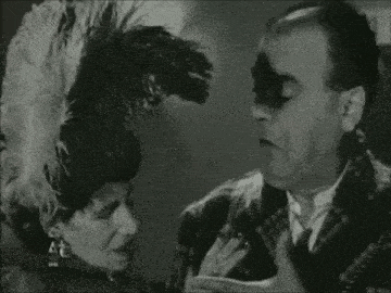 a man and a woman are standing next to each other in a room .