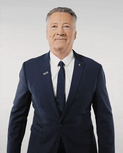 a man in a suit and tie giving a thumbs up