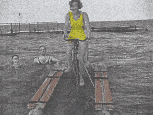 a woman in a yellow bathing suit is riding a bike on a raft in the water