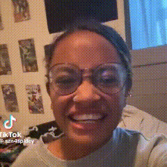 a woman wearing glasses is smiling while sitting on a couch .