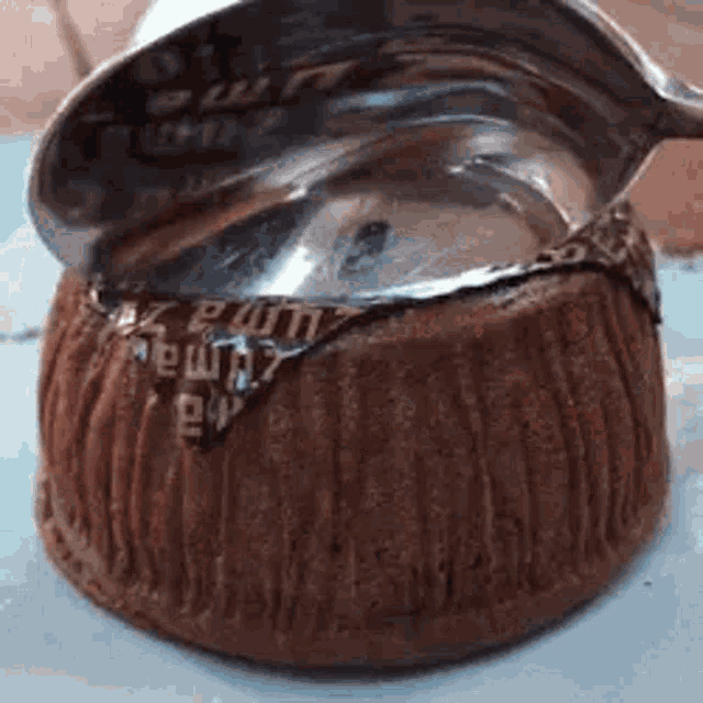 a close up of a chocolate cake with the lid open and a spoon in it .