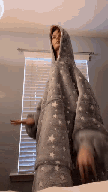 a person wearing a grey blanket with white stars on it