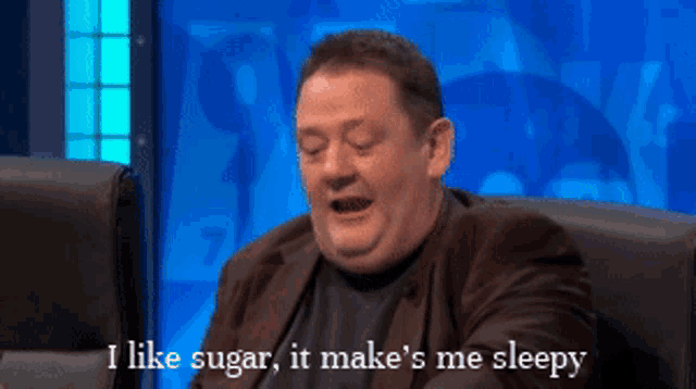 a man sitting in a chair with the words " i like sugar it make 's me sleepy " above him