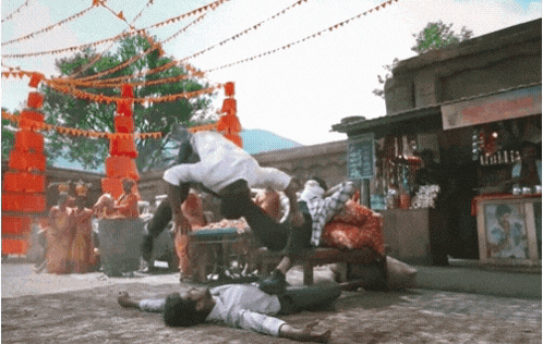 a man is doing a handstand while another man is laying on the ground in front of a store