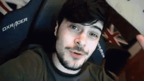 a man with a beard is sitting in a dxracer chair .