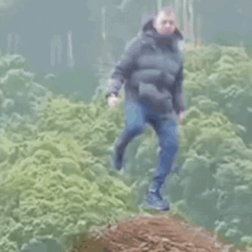 a blurry picture of a man jumping over a pile of hay