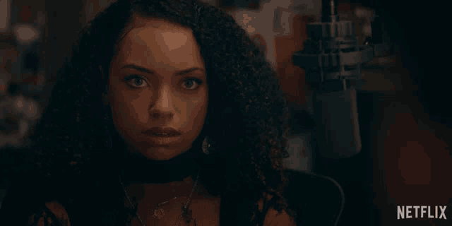 a woman with curly hair says fuck in front of a netflix sign