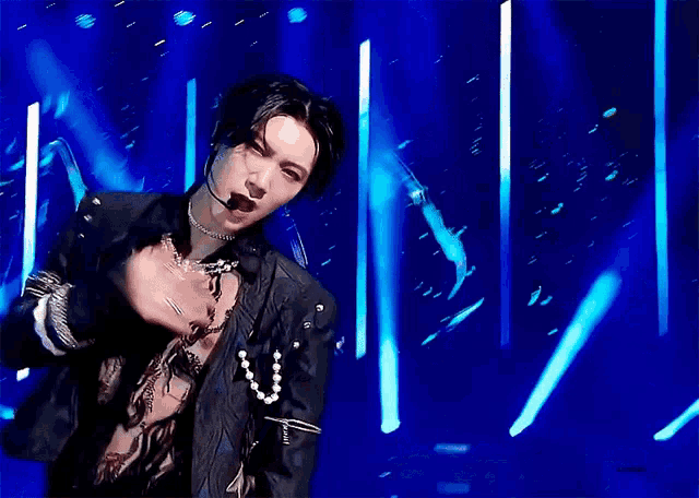 a man without a shirt is dancing on a stage with a microphone in his mouth