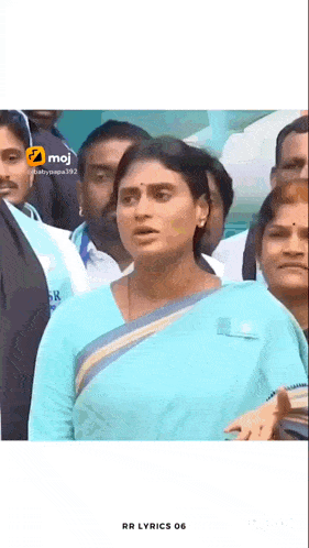 a woman in a blue dress is standing in a crowd of people .