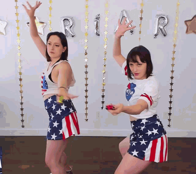 two women dancing in front of a sign that says ria r