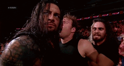 a group of wrestlers are standing next to each other in a stadium .