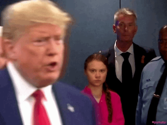 a man in a suit and tie is standing next to a girl in a pink shirt