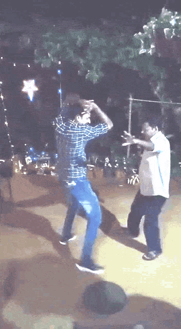 a man in a plaid shirt dancing with another man in a white shirt