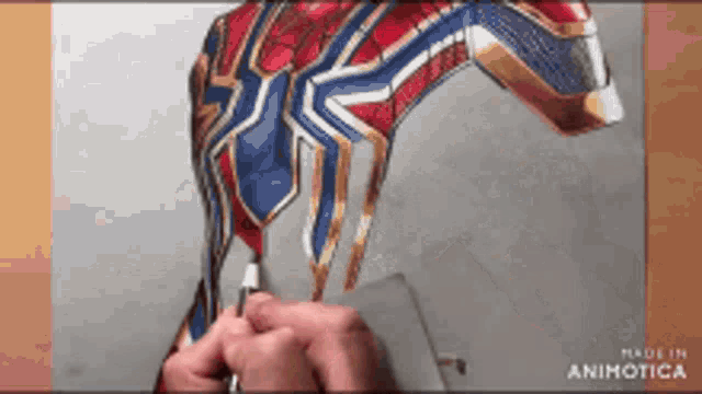 a person is drawing a spiderman costume with a pen