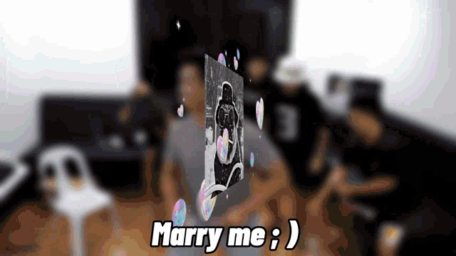 a group of people are gathered in a room and the words marry me are displayed