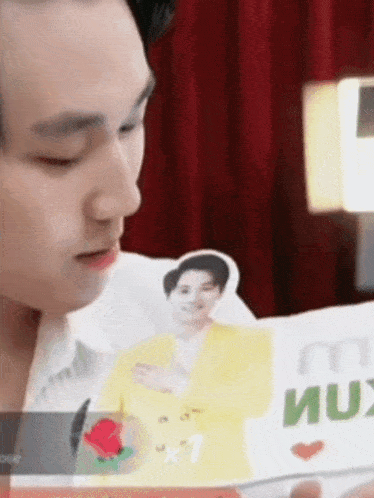 a man is holding a card with a picture of a man in a yellow jacket on it .