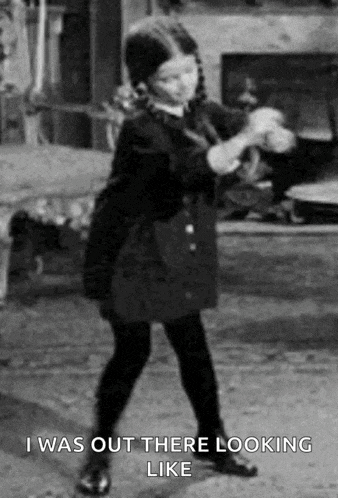 a black and white photo of a little girl dancing in a living room .