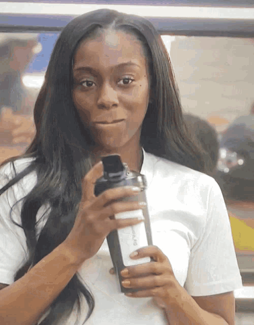 a woman in a white shirt is holding a shaker that says ' sleek ' on the side