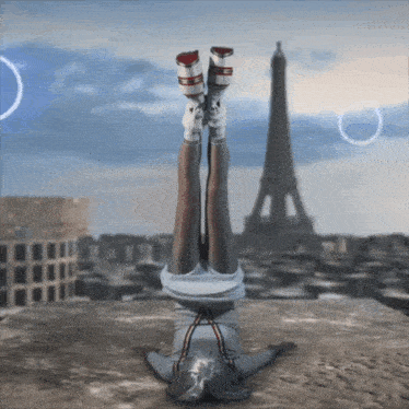 a woman is doing a handstand in front of the eiffel tower in paris