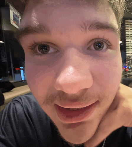 a close up of a man 's face with the word pepsi on the wall
