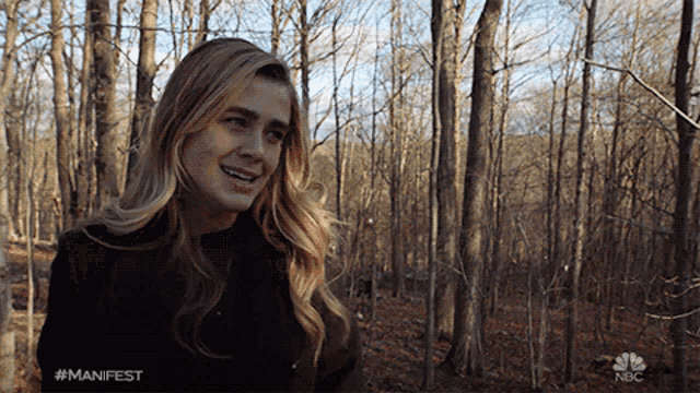 a woman in a forest with the hashtag #manifest on the bottom
