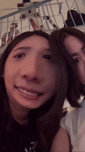 two women are posing for a picture together and one of them is smiling .