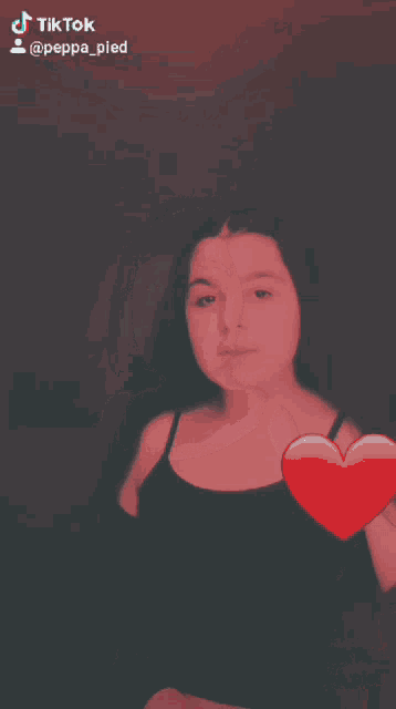 a tiktok video of a girl with a heart on her chest