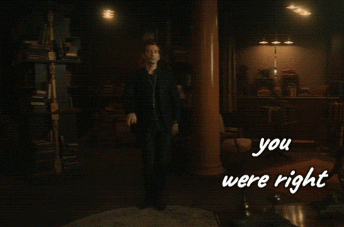 a man in a suit is dancing in a dark room with the words " you were right " on the bottom
