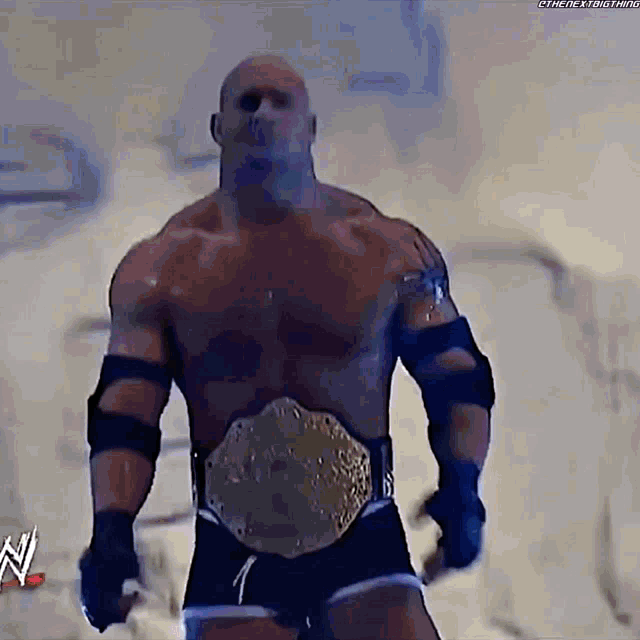 a man with a wrestling belt is standing in front of a sign that says ' n ' on it