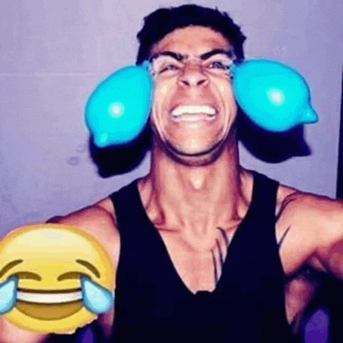 a man is making a funny face with blue balloons in his ears and holding a smiley face .