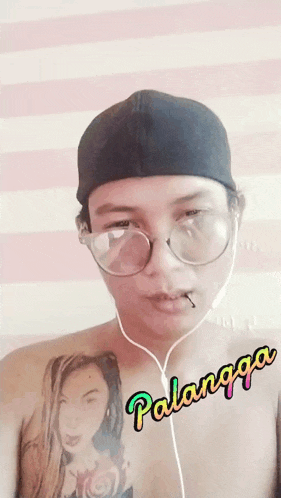 a shirtless man wearing glasses and headphones has the word palangga written on his chest