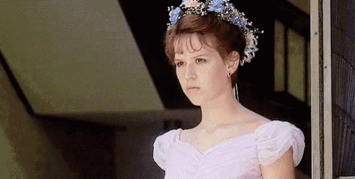 a woman in a pink dress with a flower crown on her head .