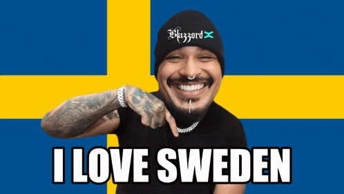 a man wearing a beanie that says blizzard on it points at the camera and says i love sweden