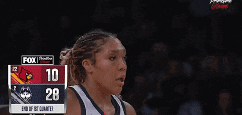 a female basketball player is pointing at the scoreboard which says 28 to 10